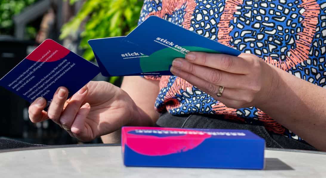 Photo of hands holding a few of the conversation cards